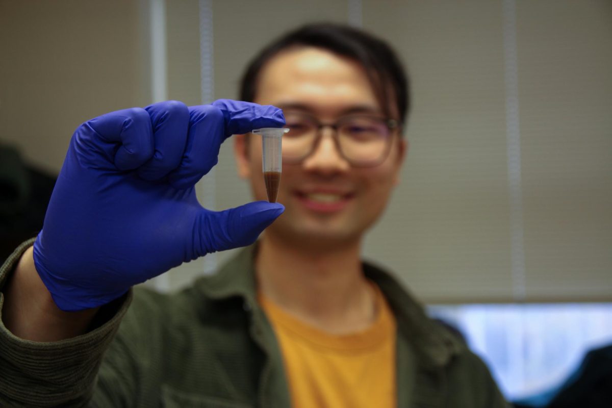 Owen Ouyang, graduate student studying biochemistry and first author of the oPool+ study, holds up part of the oPool+ display at the Wu lab in Burrill Hall on Nov. 19, 2025.