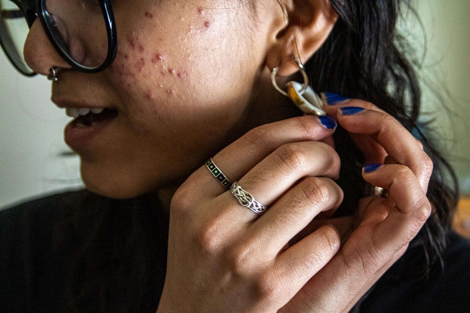 Martinez shows off an earring she made from the handle of a broken teacup.