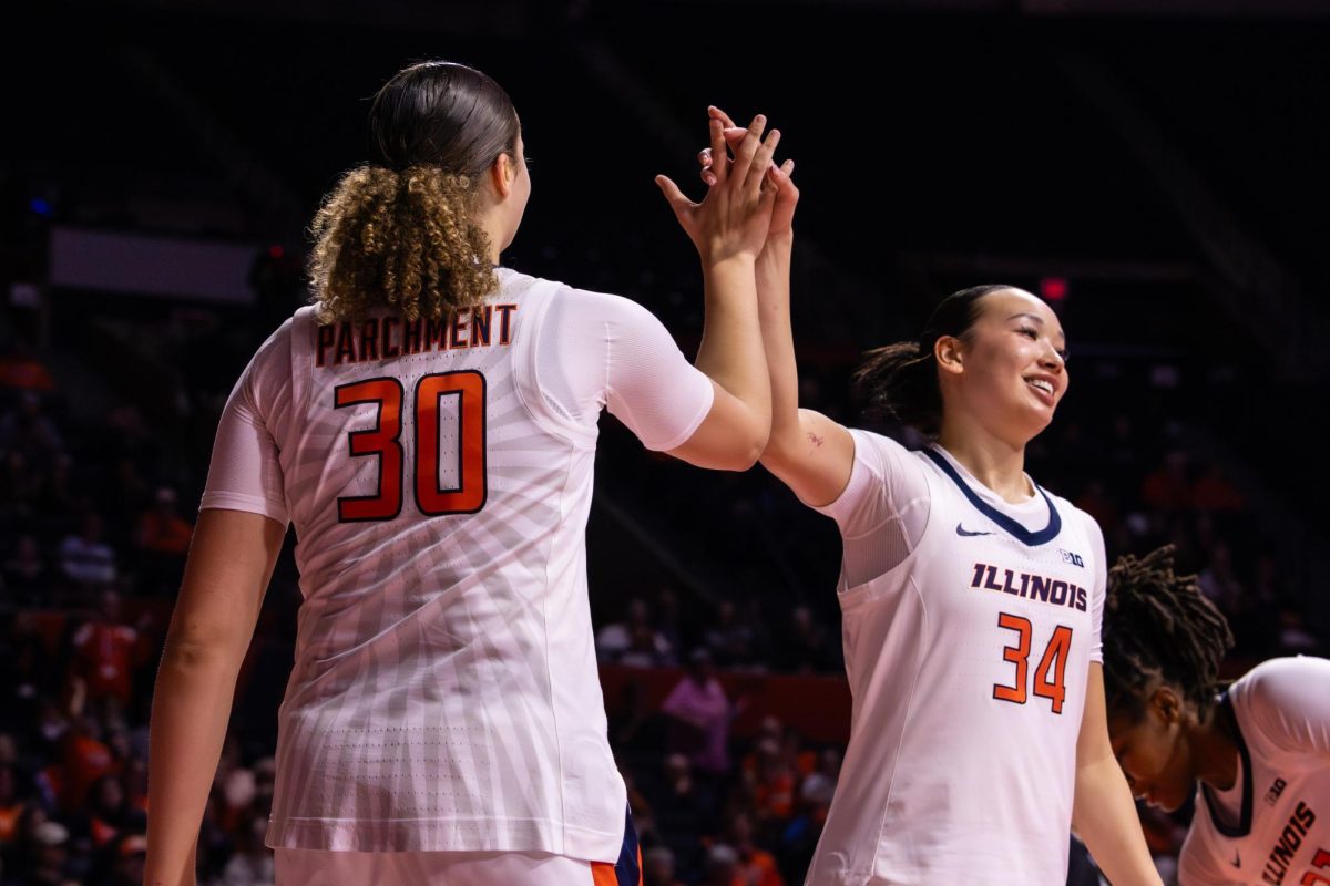 Freshman forward Cearah Parchment high fives junior guard Maddie Webber after being fouled during Illinois game against Rutgers on Tuesday.