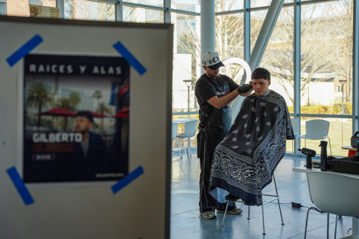 Gilberto Blendz cuts hair during the Raíces y Alas showcase at the Siebel Center for Design on Saturday. The showcase highlighted local artists who provided complimentary services to celebrate culture and community.