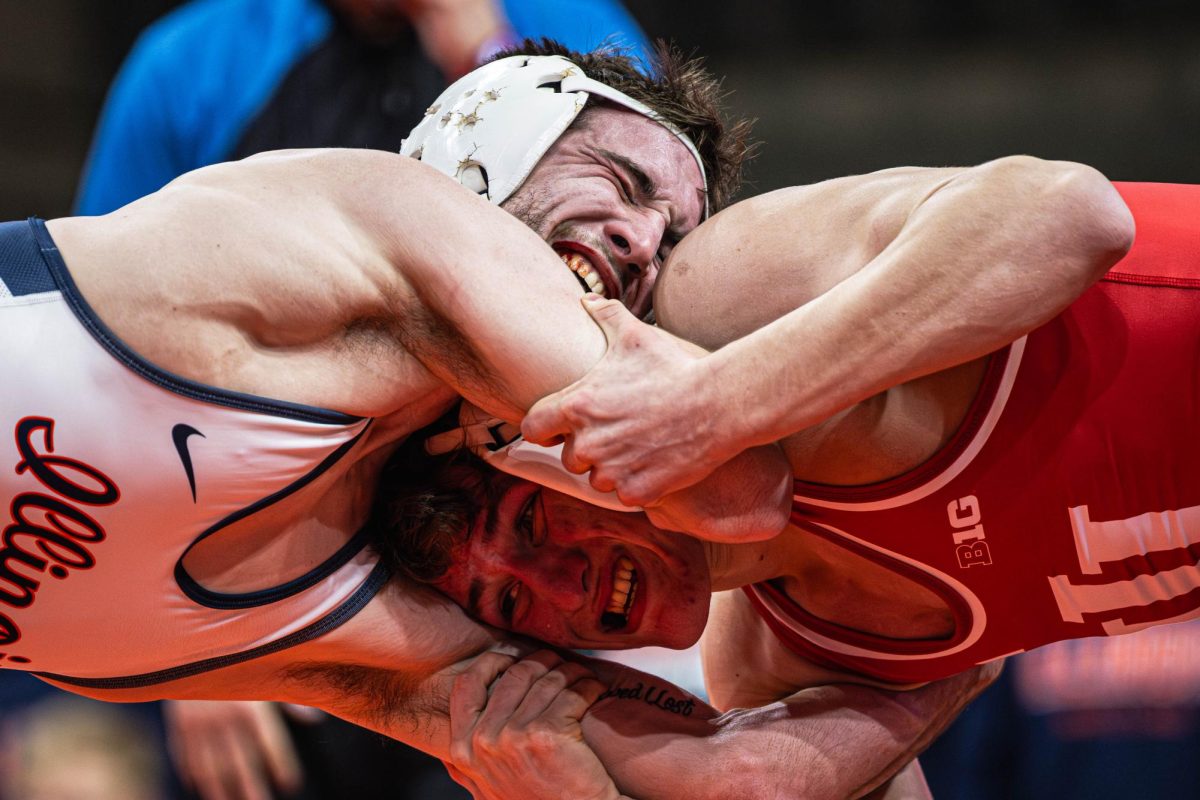 With blood stained teeth, 133lb Graduate Student Lucas Byrd presses his face against the shoulder of his opponent during the Illinois v. Indiana dual on Jan. 30.
