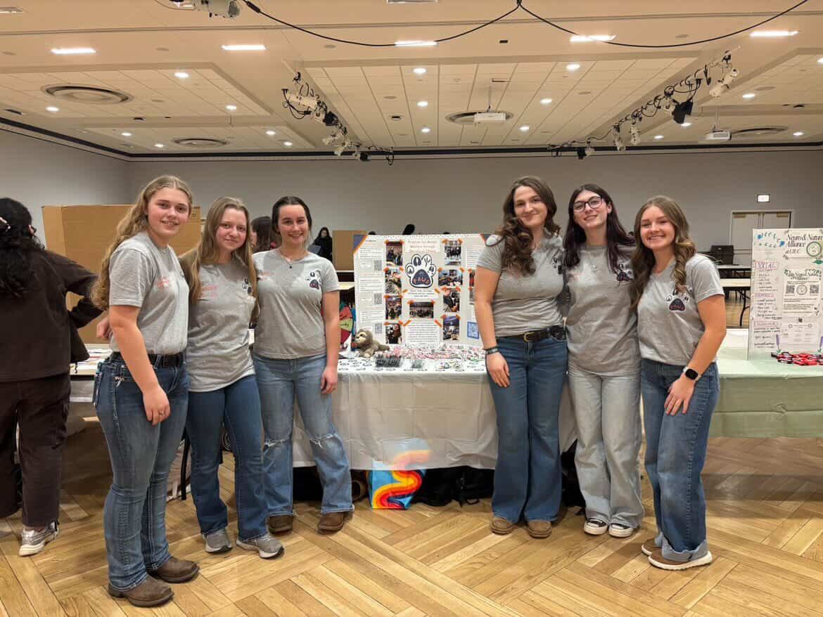 Members of the PAWS student organization pose in front of their table in the Illini Union.