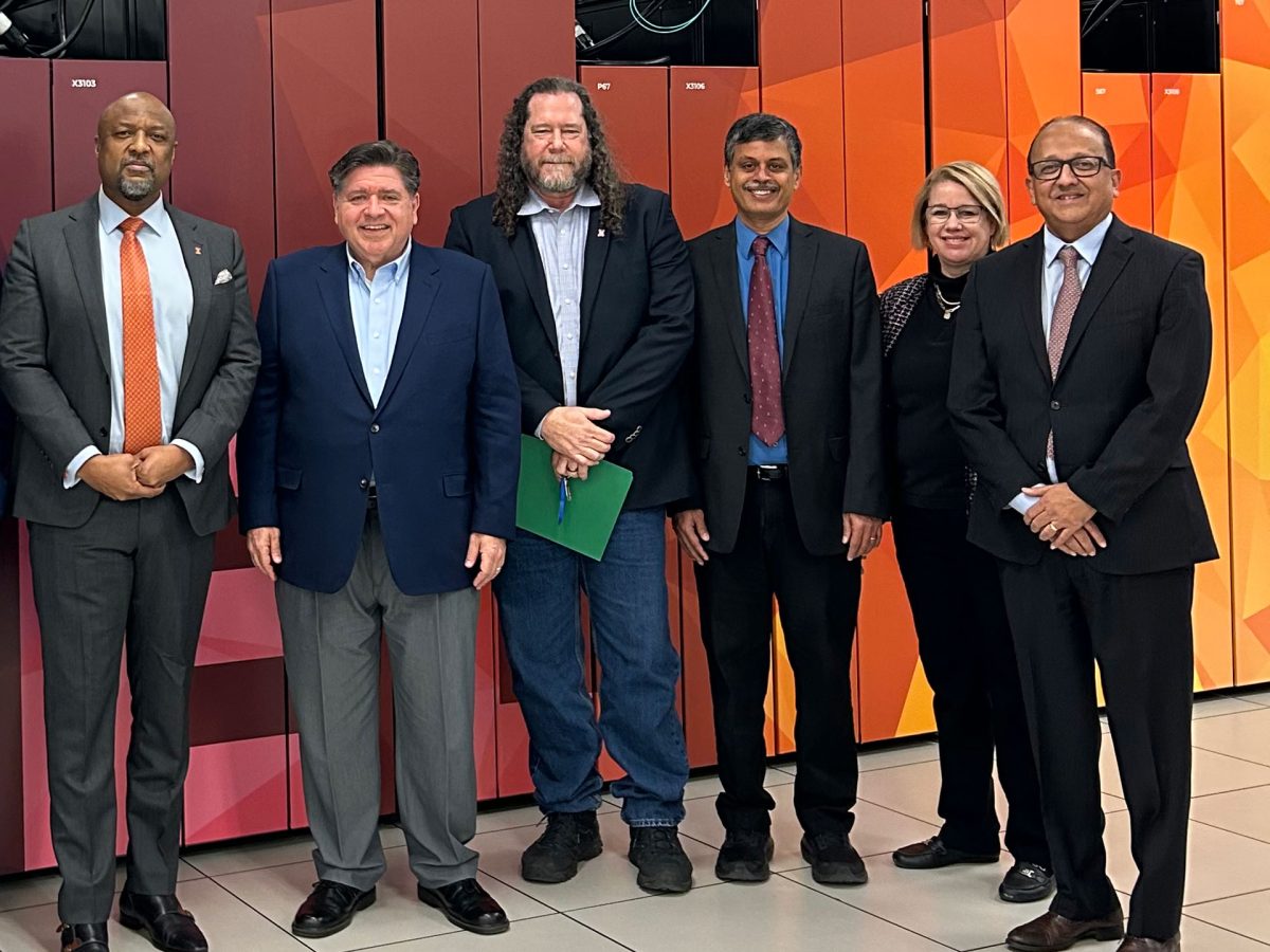 Rayadurgam Srikant, professor in Engineering and newly appointed director of the National Center for Supercomputing Applications, (right-middle, blue shirt with red tie) stands with Gov. JB Pritzker, Chancellor Charles Lee Isbell Jr., Dean of The Grainger College of Engineering Rashid Bashir and others in January.