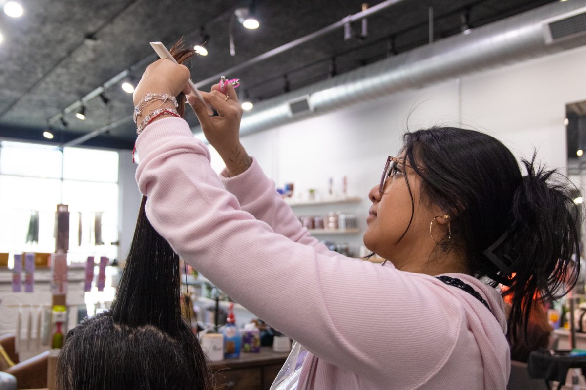 Amaris Serrano-Macedo cuts a client's hair at Allure Salon & Spa on Feb. 27. Serrano-Macedo has been a hair stylist at the establishment for three years.