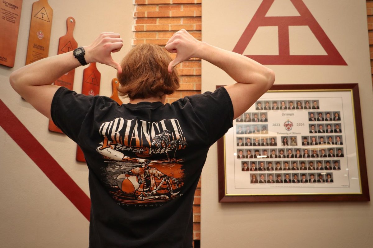 Colin, a member of Triangle, poses in front of a wall adorned with a composite and paddles on Feb. 17. Established in 1907, Triangle is the only STEM fraternity open to engineers, architects and scientists.