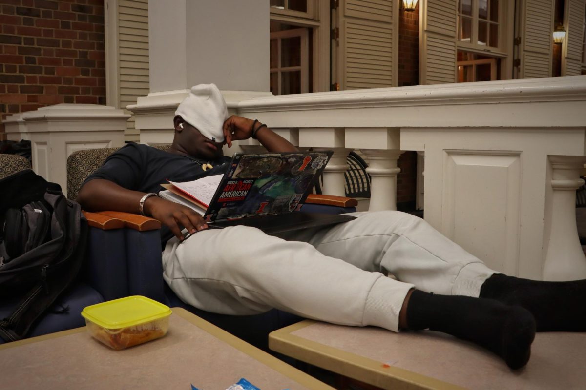 An individual rests with their feet propped up, shoes off and eyes covered at the Illini Union Feb. 19. Visitors can choose from a variety of seating options to rest in at the Illini Union, including the Underground, Courtyard Café and South Lounge.