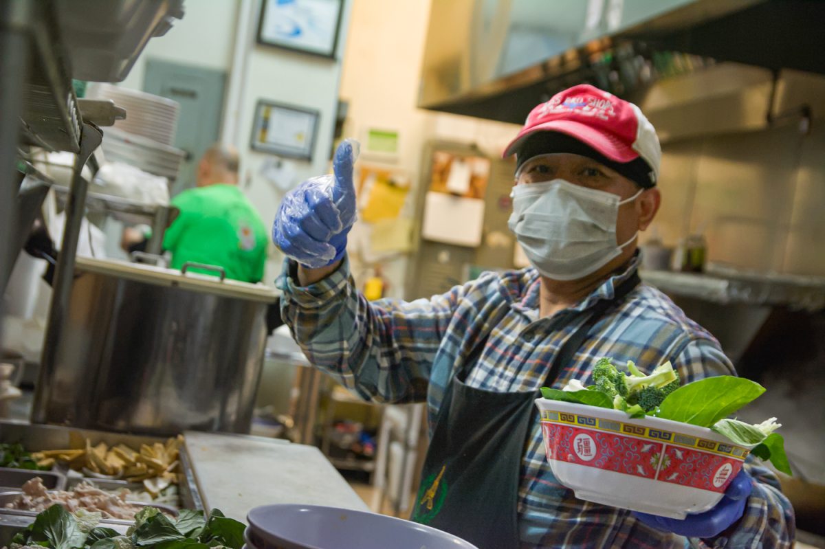 A cook poses while adding vegetables to a bowl in Bangkok Thai Restaurant and Pho 911, located at 410 E. Green St. in Champaign on Feb 21. The restaurant, whose menu includes items like pad thai, yellow curry, basil chicken and spring rolls, is open every day from 11 a.m. to 9 p.m.