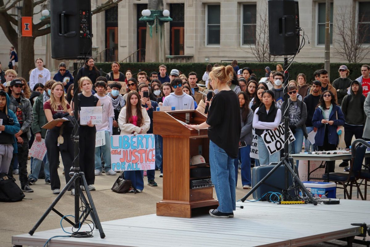 Samantha Webb, a member of Illini Democrats and sophomore in LAS, speaks to attendees as the crowd looks on during an anti-Immigration and Customs Enforcement rally Feb. 28. 