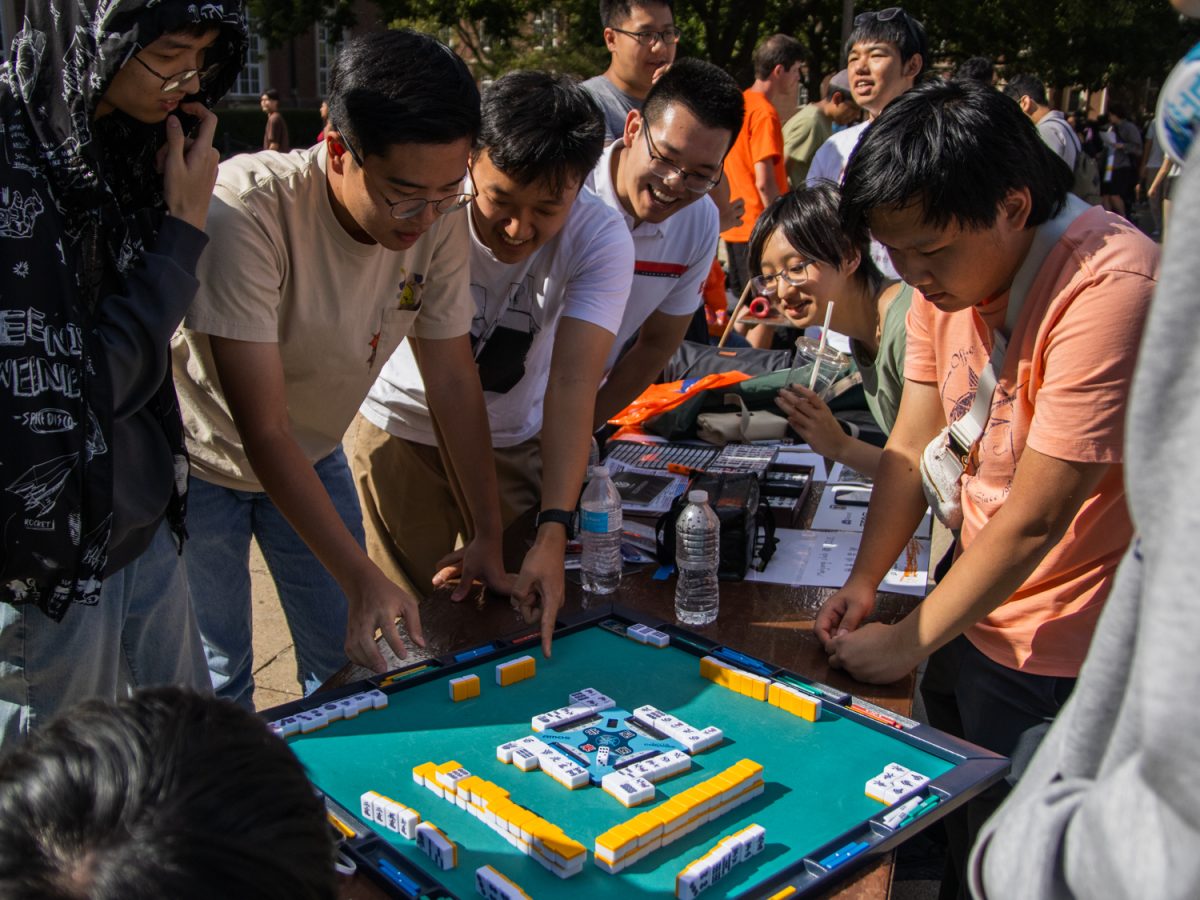 Members of the Mahjong Club at Illinois and interested students play a game at the club’s table on Quad Day on Aug. 24, 2025.