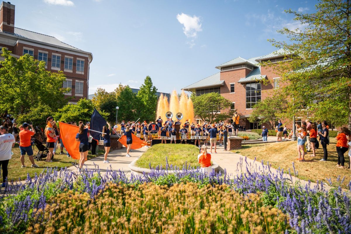 Orange water springs from the Alice Campbell Alumni Center fountain at the Illinois Homecoming kickoff Sept. 21, 2025. The fountain's water is dyed orange every year as a homecoming tradition.
