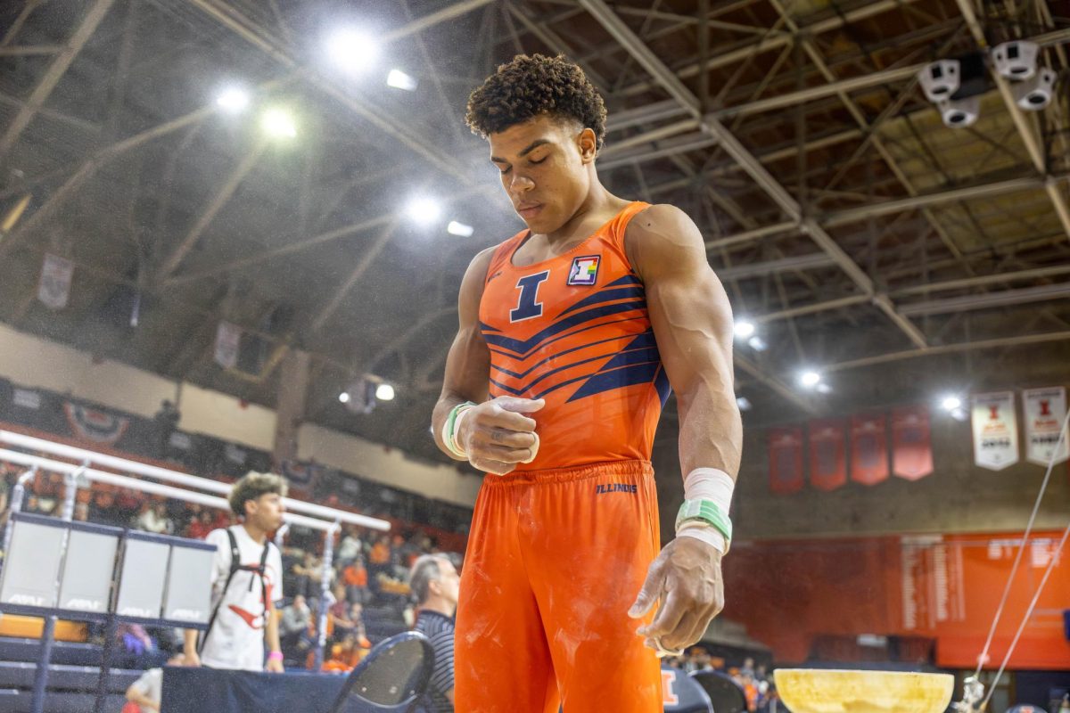 Graduate student Sam Phillips closes his eyes and breathes in and out before performing his still rings routine at the gymnastics meet against Ohio State on March 7 in Huff Hall. 