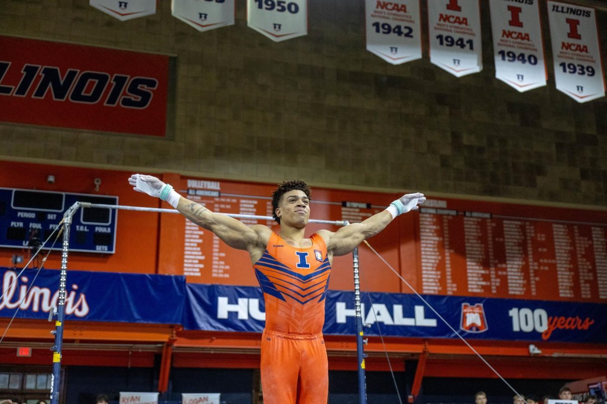 Graduate student Sam Phillips salutes after his high bar routine at the gymnastics meet against Ohio State on Saturday in Huff Hall. 