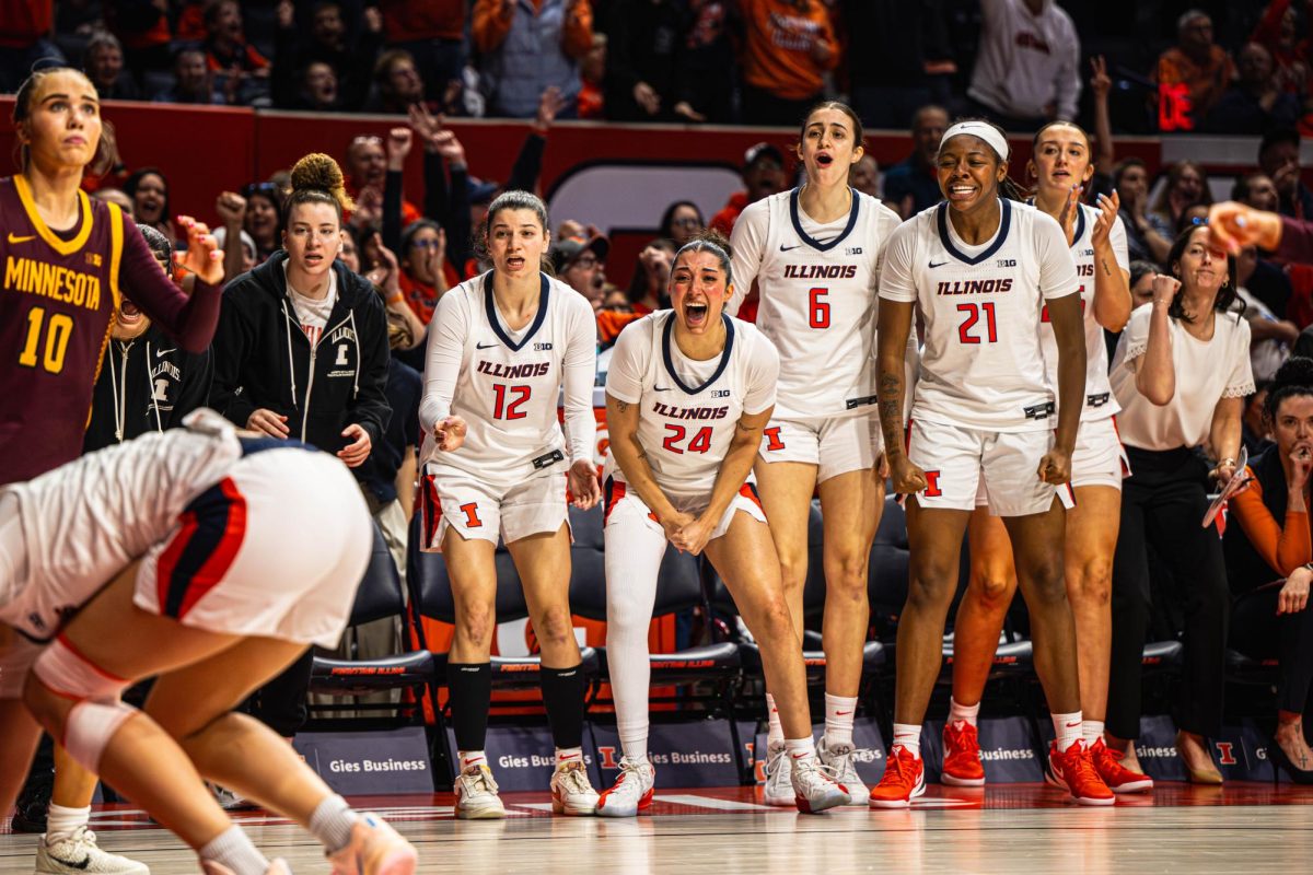 The Illinois bench celebrates a late game layup during their game against Minnesota on March 1. Illinois would go on to lose the game 73-78.