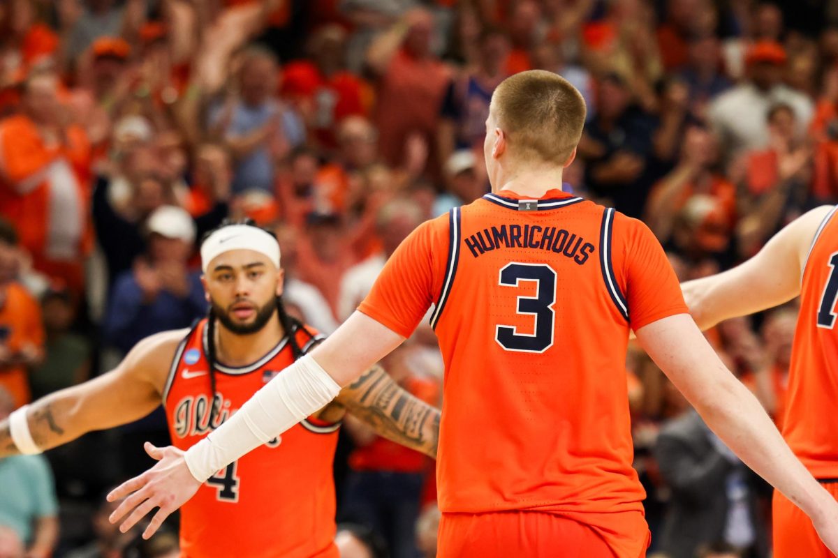Graduate student forward Ben Humrichous goes to high-five senior guard Kylan Boswell during Illinois’ March 21 win in the second round of the NCAA tournament.