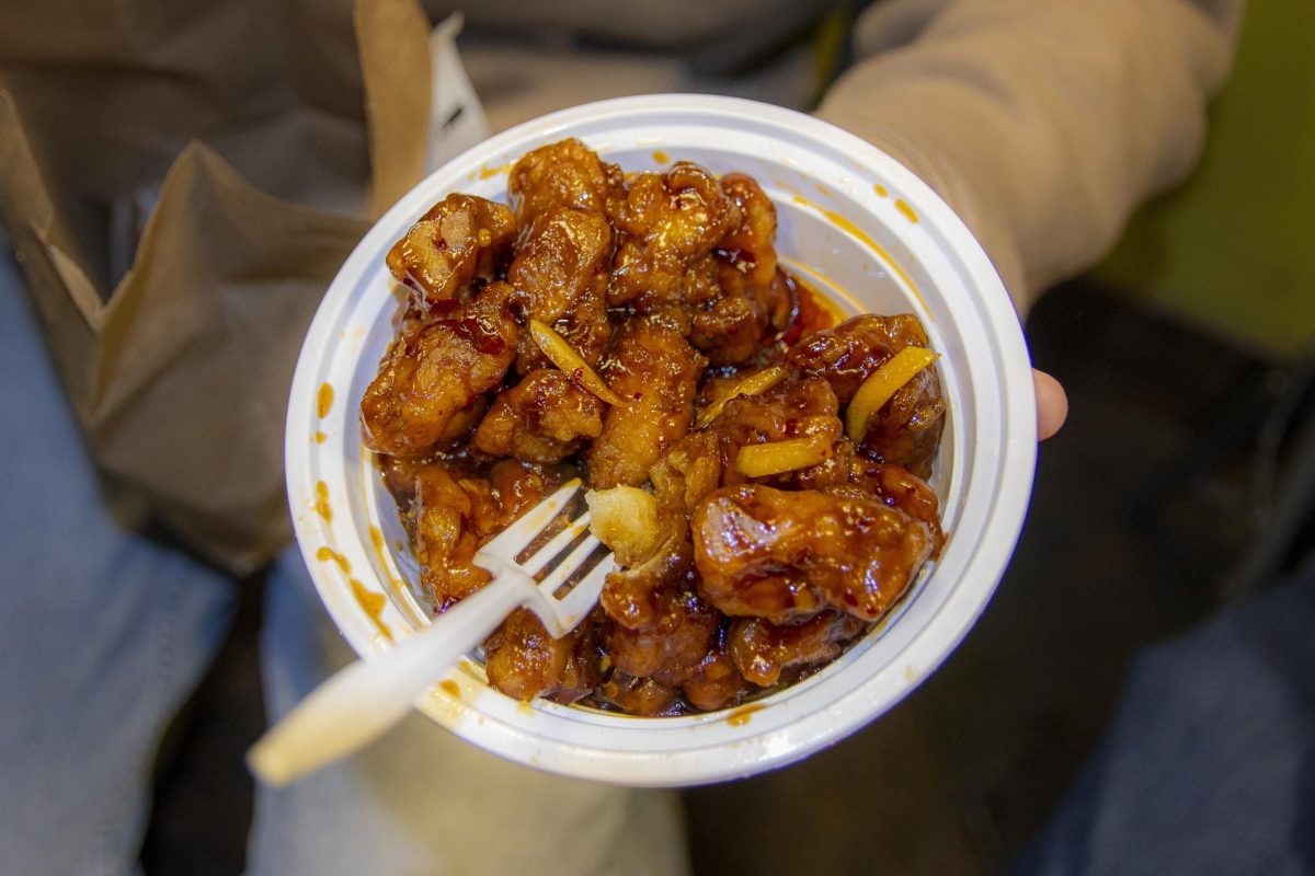 A student holds a bowl of orange chicken from Chopstix on Feb. 28. Chopstix is open from 4 p.m. to 3 a.m. seven days a week.