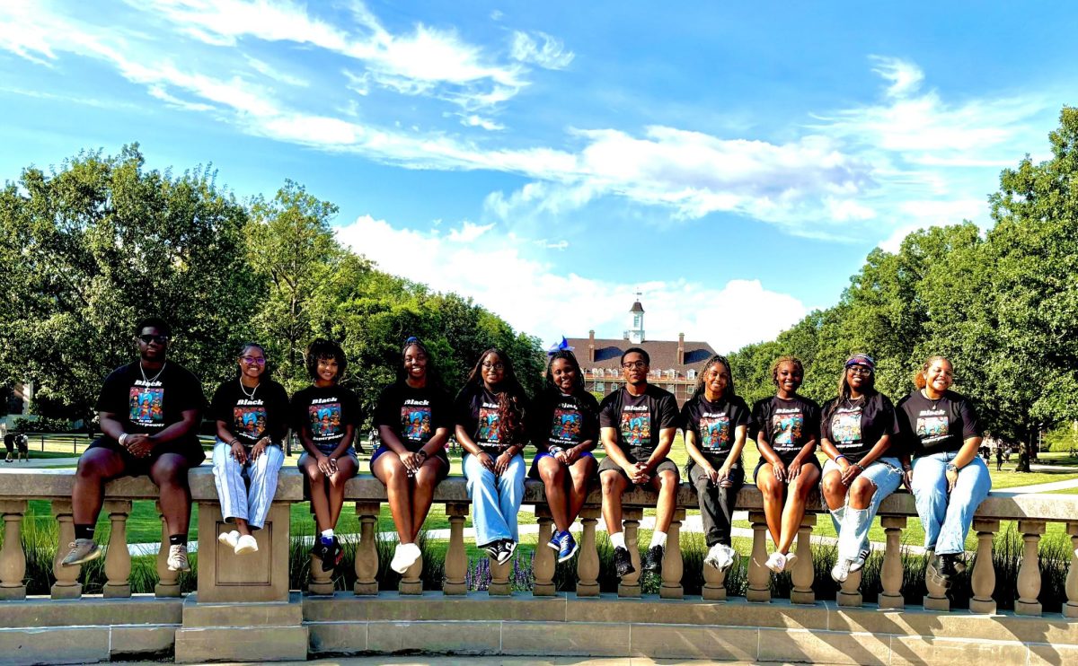 Members of 100 Strong pose for a photo outside of Foellinger Auditorium.