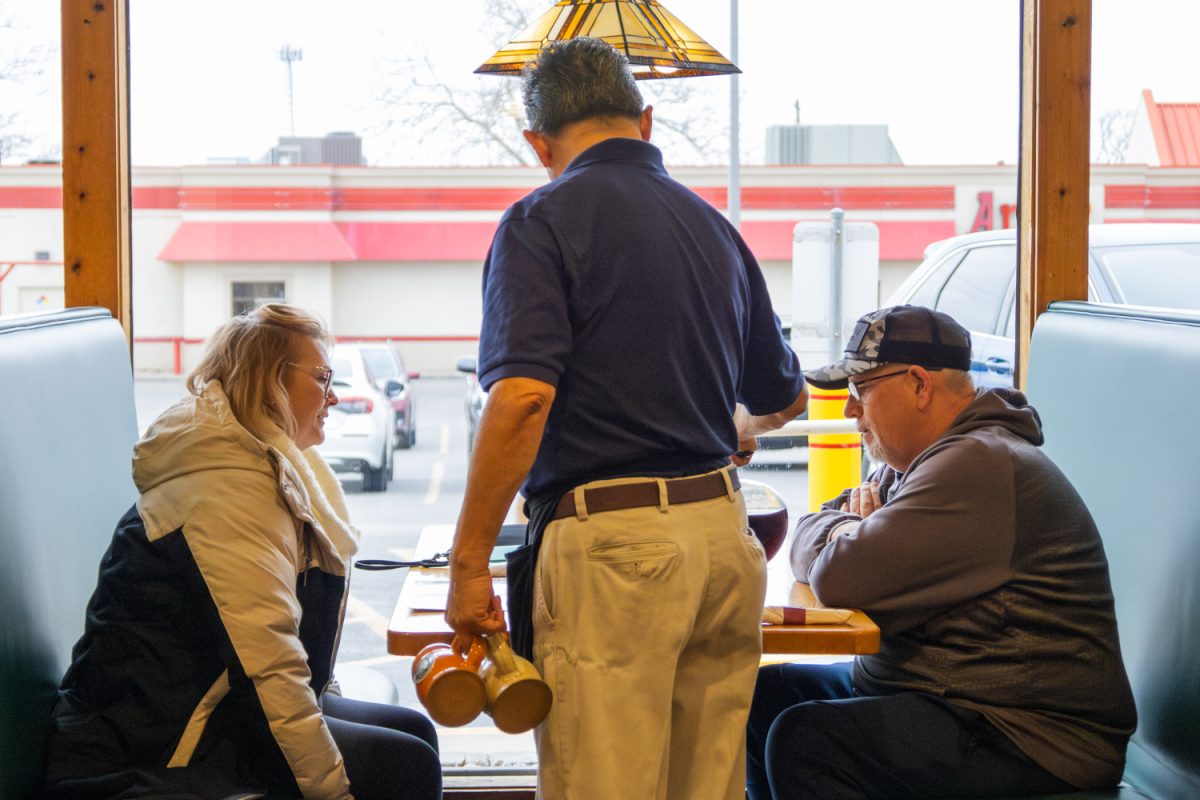 A waiter pours coffee for two customers of The Original Pancake House on March 3, 2025.