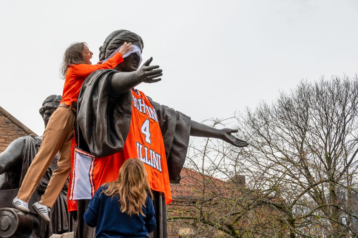 Senior guard Kylan Boswell’s signature headband slips down the Alma Mater’s face as University admin members dress the statue Thursday morning ahead of the Illini's Final Four basketball game on Saturday.