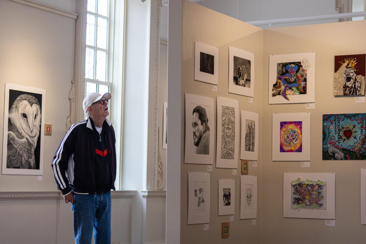 A spectator views the art on display of The Eric Show high school art competition in the Illini Union on April 3. The art has been on display since March 11 and the last day to view it is April 5.