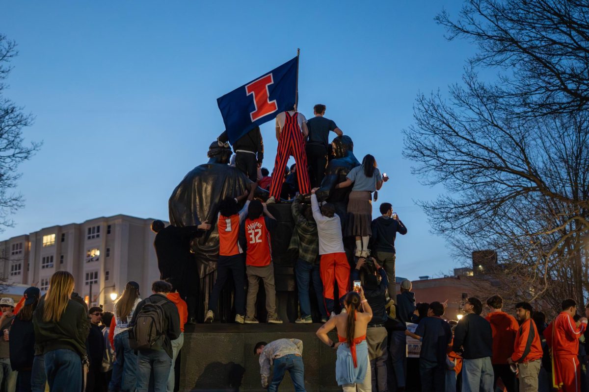 Fans climb Alma Mater after Illinois beat Iowa to advance to the Final Four.