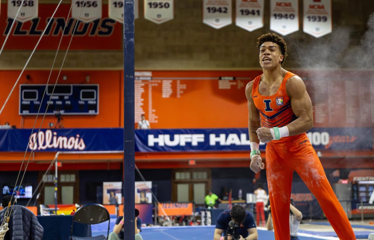 Graduate student Sam Phillips celebrates after performing his still rings routine at the gymnastics meet against Ohio State on March 7 in Huff Hall. Phillips scored a 13.05 on this routine.