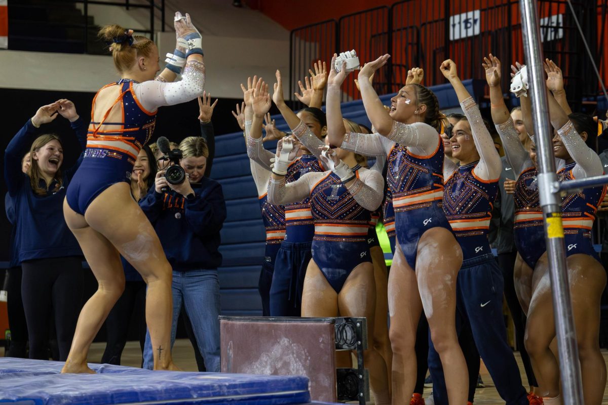 Junior Lyden Saltness high fives her teammates at the gymnastics meet against Alabama in Huff Hall on Mar 8. Saltness scored a 9.925 on this routine.