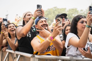 Multiple crowd members cheering and recording some of Skrillex’s set.