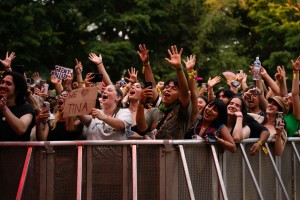 Festival goers raise their hands and signs as the concert goes on.