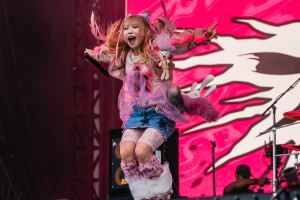 Yukina jumps in the air as music blasts from the stage speakers.