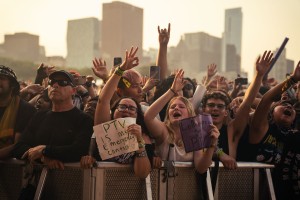 Crowd members in excitement raise their hands in the air during the golden hour stage performance from Pierce the Veil.