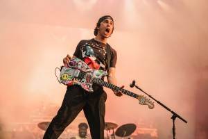 Vic Fuentes shouts as the band continues to play.