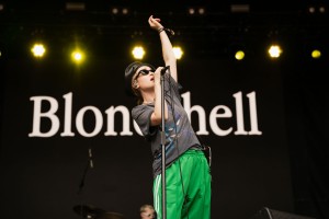 Blondshell raises her hand in the air as she sings to the audience of the Bacardi stage.