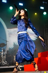 Tenenbaum runs across the stage with big strides as her outfit flows behind her.