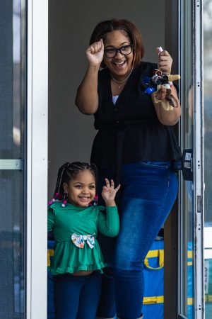 A woman and child wave and cheer on protesters as they march down Green Street on Jan. 30.