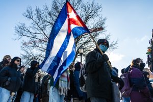 A protester carries a Cuban flag as the crowd begins to walk down Green Street on Jan. 30.