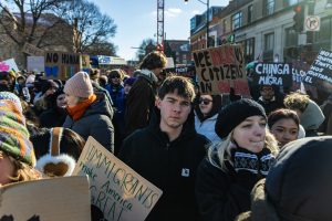 Protesters move to fill the intersection of Wright and Green Streets, holding signs critiquing immigration enforcement on Jan. 30.