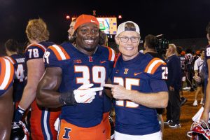 Senior linebacker Kenenna Odeluga takes a photo with Larry Gies after defeating Western Michigan.