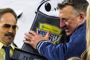 Head coach Bret Bielema recieves the Music City Bowl trophy from Liberty Mutual's fictional spokesperson, Doug, on Dec. 30, 2025. The game marked Bielema's sixth career bowl win and second with Illinois.