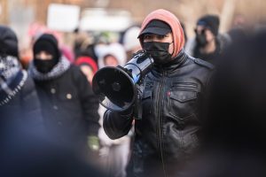 One of the protest leaders uses his megaphone to shout out to the crowd that surrounds him during the walk out against ICE on Jan. 30.