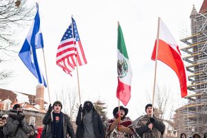 A group of protesters hold their flags high as they stand in front of the Alma Mater during the anti-ICE protest on Jan. 30.