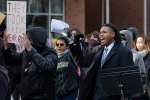 A protester marches with a music stand and yells chants with the rest of the crowd on Jan. 30. This protester would later give a speech in the circle that formed at the intersection of First and Green Streets.