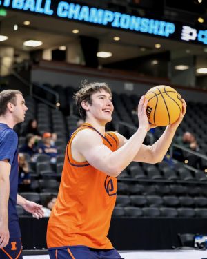 Freshman forward David Mirković shoots a 3-pointer and smiles during Illinois’ March 19 open practice in Greenville, South Carolina.