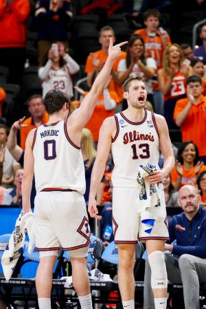 Junior center Tomislav Ivišić screams in celebration after the Illini made a three during the first half of their win over the Quakers March 19.