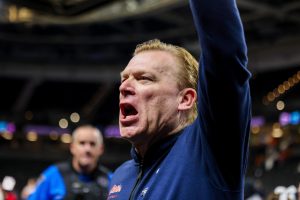 Illini head coach Brad Underwood screams in celebration toward his team’s fans after defeating the Quakers in the first round of March Madness on March 19.