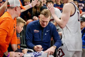 Illini head coach Brad Underwood stops in the tunnel to sign a young fan’s shirt as he exits the court following a first-round NCAA tournament win over Penn March 19.