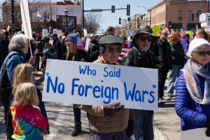 A protester holds up a sign reading “Who said ‘No Foreign Wars’”’ at the No Kings 3 protest in downtown Urbana Saturday afternoon.