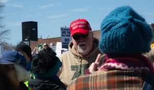 A protester shows her middle finger to a man wearing a “Make America Great Again” hat at the 3rd No Kings protest outside of the Champaign County Courthouse on Saturday.