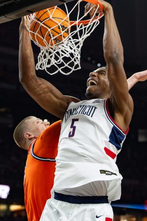 UConn senior center Tarris Reed Jr. dunks the ball over Illinois graduate student forward Ben Humrichous.