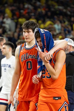 Freshman forward David Mirkovic puts his arm around freshman guard Keaton Wagler as they walk off the floor.
